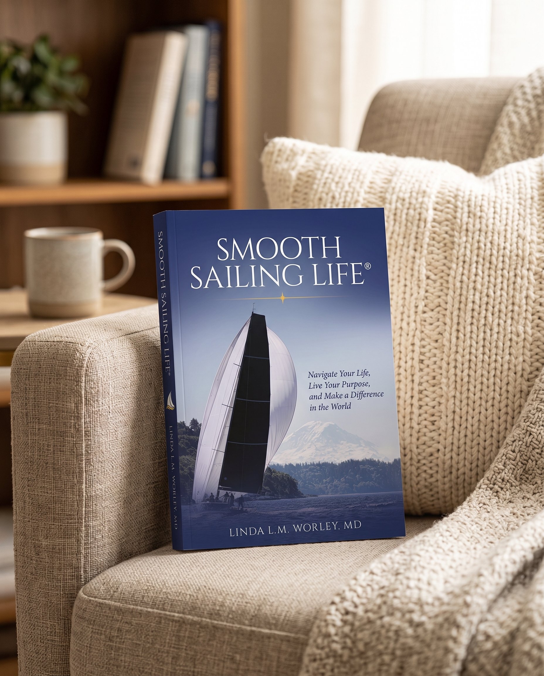 Smooth Sailing Life paperback by Linda L.M. Worley, MD, resting on a cozy armchair beside a knit throw